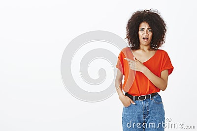 Indoor shot of shocked displeased good-looking female with curly hair, frowning and expressing dislike and antipathy Stock Photo