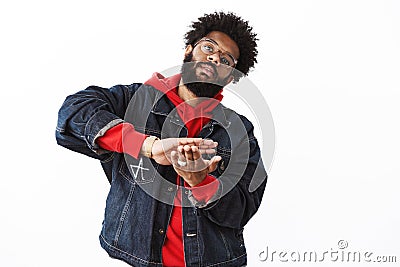 Indoor shot of stylish and arrogant african american bearded guy in street-style clothes tilting head as sweep money Stock Photo