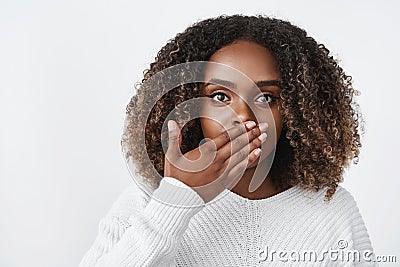 Indoor shot of surprised and stunned woman gasping from shock cover mouth speechless and amazed looking worried at Stock Photo