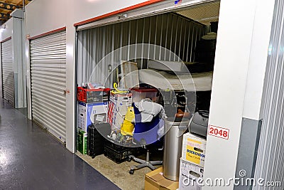 Indoor storage unit with open door and household goods in a self storage facility. Rental Storage Units. Netherlands Editorial Stock Photo