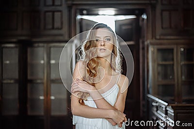 Indoor summer portrait of young pretty cute girl. Beautiful woman posing beside fairytale door inside wood cabinet, scars old cast Stock Photo