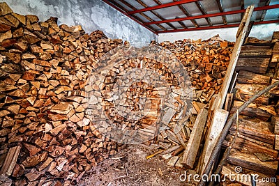 Indoor woodshed with nicely arranged chopped firewood Stock Photo