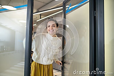 Young woman standing at the door, smiling happily Stock Photo