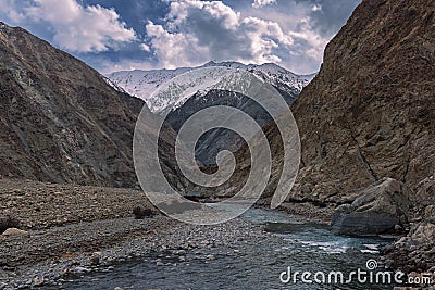 Indus Flow: Majestic Serenity of Ladakh's Barren Valley with Snowcapped Peaks and Tranquil Waters Stock Photo