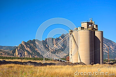 Industrial Agriculture Elevator Silo with Mountains Stock Photo