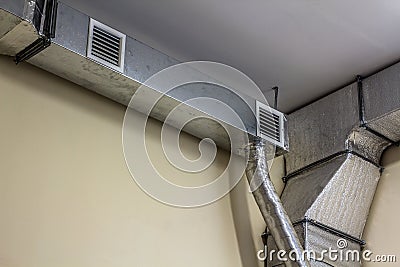 Industrial air duct ventilation equipment and pipe systems installed on industrial building ceiling. Stock Photo