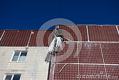 Industrial alpinism. worker closes the gap between the panels of the house outside. Maintenance of an apartment building Stock Photo