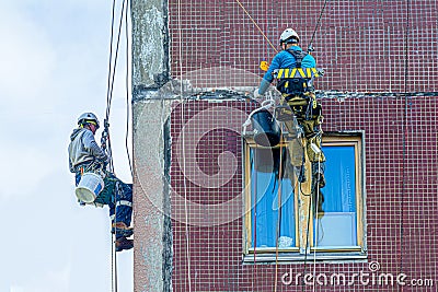 Industrial alpinism. Workers are restoring the building. Mountaineering, repairs, dangerous work at height Stock Photo