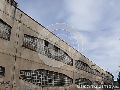 Industrial archeology buildings in the city of Busto Arsizio. Facade of an old factory with glass block windows Editorial Stock Photo