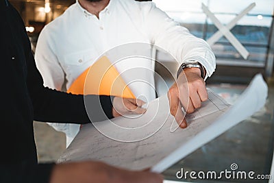 Industrial architect discussing build drawing with worker wearing safety hard hat Stock Photo