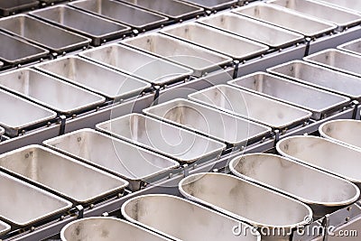 Industrial bakery automated line. Filling metal molds for baking bread Stock Photo