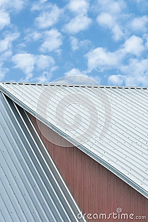 Industrial building roof sheets, grey steel rooftop pattern, bright summer clouds cloudscape, blue sky, rifled roofing panels Stock Photo