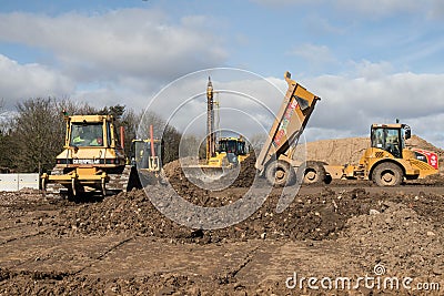 Industrial bulldozer and truck moving earth on a construction site Editorial Stock Photo