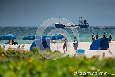 Industrial cargo ship departing Miami. Blurry people in foreground Editorial Stock Photo