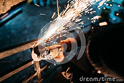 Industrial caucasian male worker, close up workers hands with power tool with circular blade grinder Stock Photo