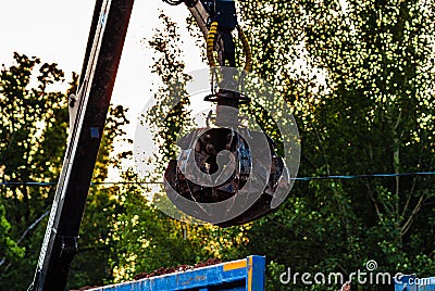 Industrial claw machine. Excavator arm on the trash truck. claw crane on dump truck. Closeup view of closed claw Stock Photo