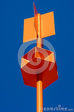 Industrial, complex shape, metal, orange sea buoy. An metal pipe in foreground Stock Photo