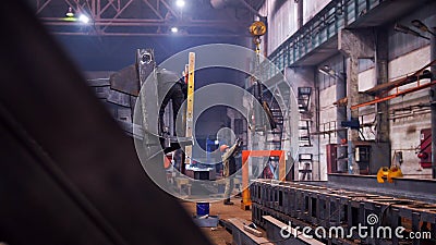 Industrial concept. A crane put down the detail on the floor and man worker taking it Editorial Stock Photo