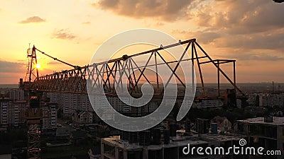 Industrial construction cranes and building silhouettes over sunset background and sunrise Stock Photo