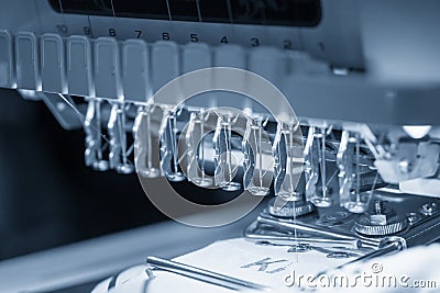 The industrial embroidery machine operation in the light blue scene. Stock Photo