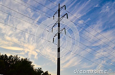 Industrial environment from evening to dawn time. Countryside romantic view with trees silhouettes, electricity pillars and wires Stock Photo