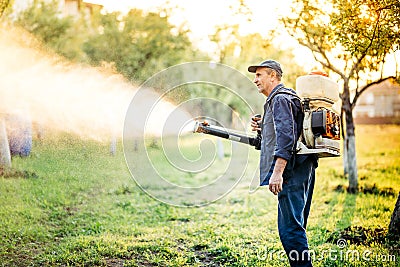 Industrial farm worker doing pest control using insecticide Stock Photo