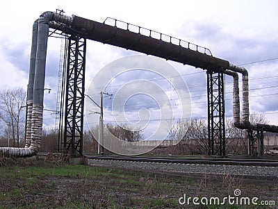 Industrial heat pipe over railway rails working landscape Stock Photo