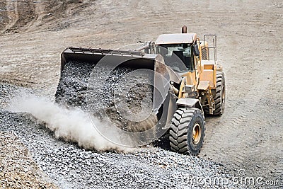 Industrial heavy bulldozer moving gravel on highway construction site Stock Photo