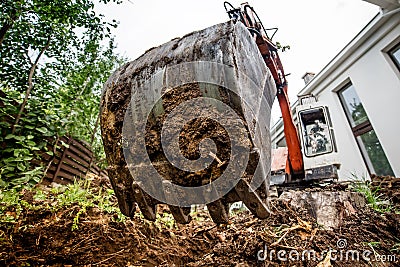 Industrial heavy duty excavator digging at construction site. Close-up of scoop and metal bucket Stock Photo