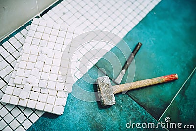 Industrial home construction - Hammer and mosaic, white marble stone ceramic tiles Stock Photo