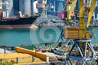 Industrial infrastructure of the seaport, the sea, cranes and railway wagons, grain silo, bulk carrier vessel and grain storage Stock Photo