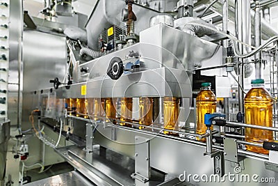 Industrial interior of natural juice plant production. Conveyor belt, filled bottles on beverage factory, industry Stock Photo