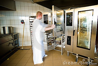 Industrial kitchen interior with busy cooks Stock Photo