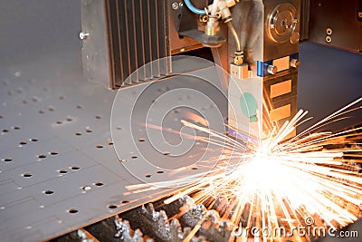 Industrial laser making holes in metal sheet Stock Photo