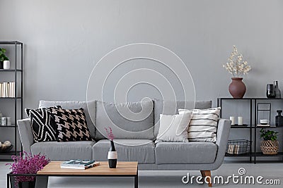 Industrial living room with simple grey sofa with copy space on the wall Stock Photo