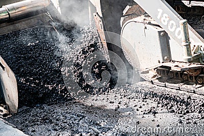 Industrial pavement machine laying fresh asphalt on highway construction site Stock Photo