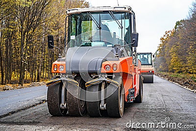 Industrial pavement machine laying new fresh asphalt.Fresh asphalt on highway construction site. Stock Photo