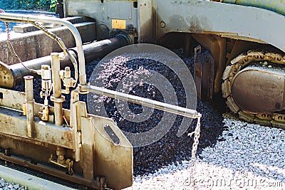 Industrial pavement truck laying fresh asphalt on construction site.Road works Stock Photo