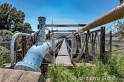 Industrial pipeline carrier structure over river bridge Stock Photo