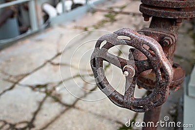 Industrial pipeline and valve close up, blur concrete background. Old rusty control equipment, abandoned plant industry with Stock Photo