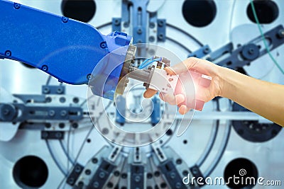 Industrial robot handshake with human on relationship for working on industrial manufacturing Stock Photo