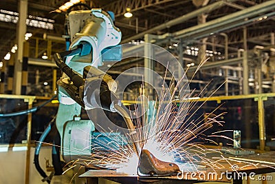Industrial robot is welding automotive part in factory Stock Photo