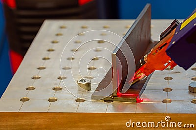 Industrial welding robotic arm scanning metal workpiece with laser scanner Stock Photo