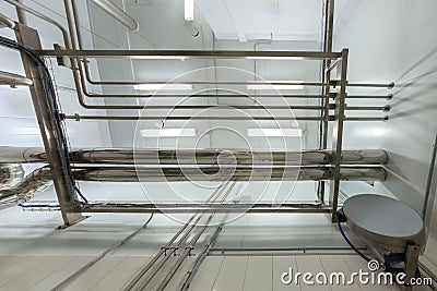 Industrial shiny steel pipeline overhead ceiling upward background. Chemical laboratory and science style. Stock Photo