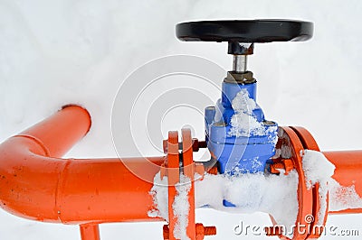 Industrial shut-off regulating protective pipe fittings. Black valve for opening, closing on an iron orange metal pipe with Stock Photo