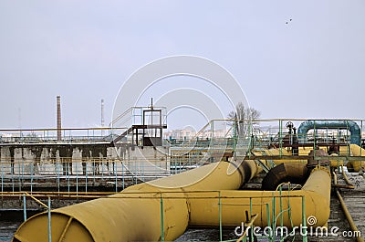 Industrial space with lots of pipes and communications on a background of blue sky. old water treatment plant on the city`s water Stock Photo