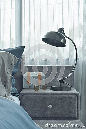 Industrial style reading lamp next to blue color scheme bedding Stock Photo