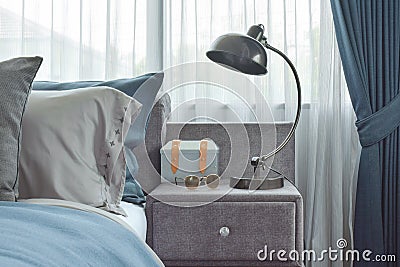 Industrial style reading lamp next to blue color scheme bedding Stock Photo