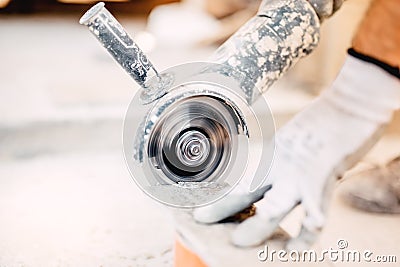 Industrial tool, grinder cutting piece of stone. Marble cutting at construction site Stock Photo