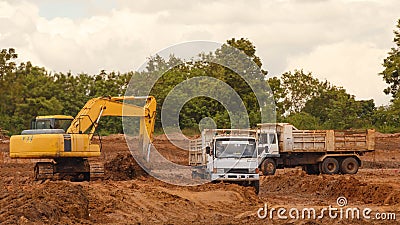 Industrial truck loader excavator moving earth and unloading int Stock Photo